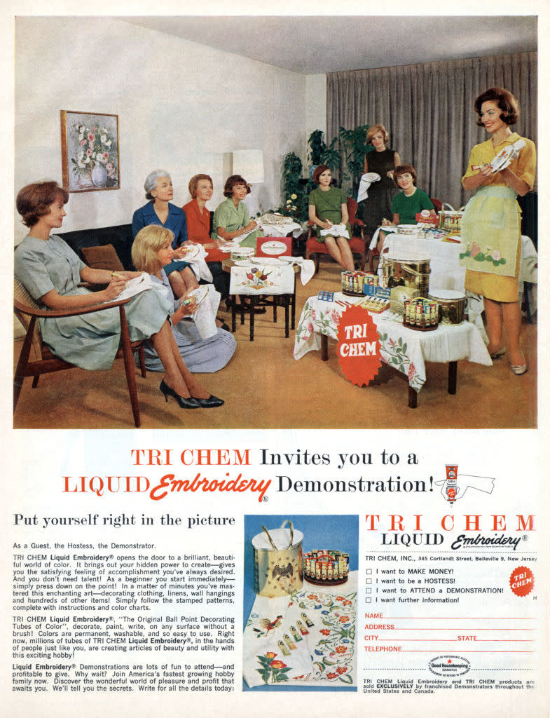 A group of women gather in a living room for a Tri Chem Liquid Embroidery demonstration. A hostess shows various embroidery products and techniques on tables