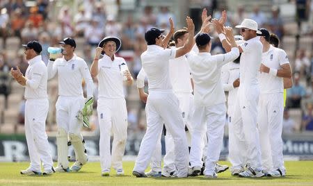 England's Stuart Broad (3rd R in hat) celebrates with team-mates including Joe Root (3rd L) after dismissing India's Murali Vijay run out during the third cricket test match at the Rose Bowl cricket ground, Southampton, England July 30, 2014. REUTERS/Philip Brown