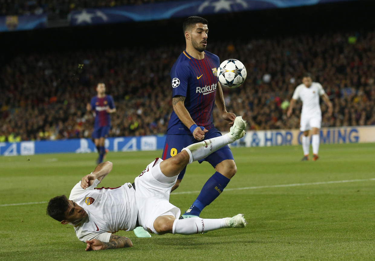 Roma’s Diego Perotti tries to stop Barcelona’s Luis Suarez during the Champions League quarterfinal first leg at Camp Nou. (AP)