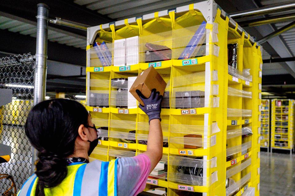 Person putting package on shelf in Amazon warehouse