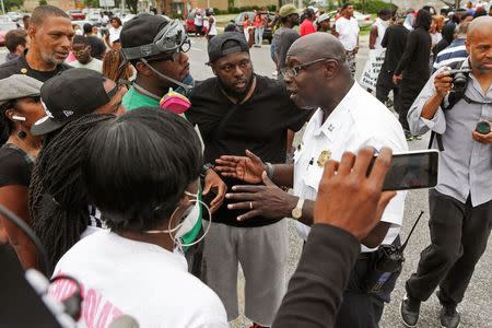 Police and residents talk after a shooting incident in St. Louis, Missouri August 19, 2015. REUTERS/Lawrence Bryant