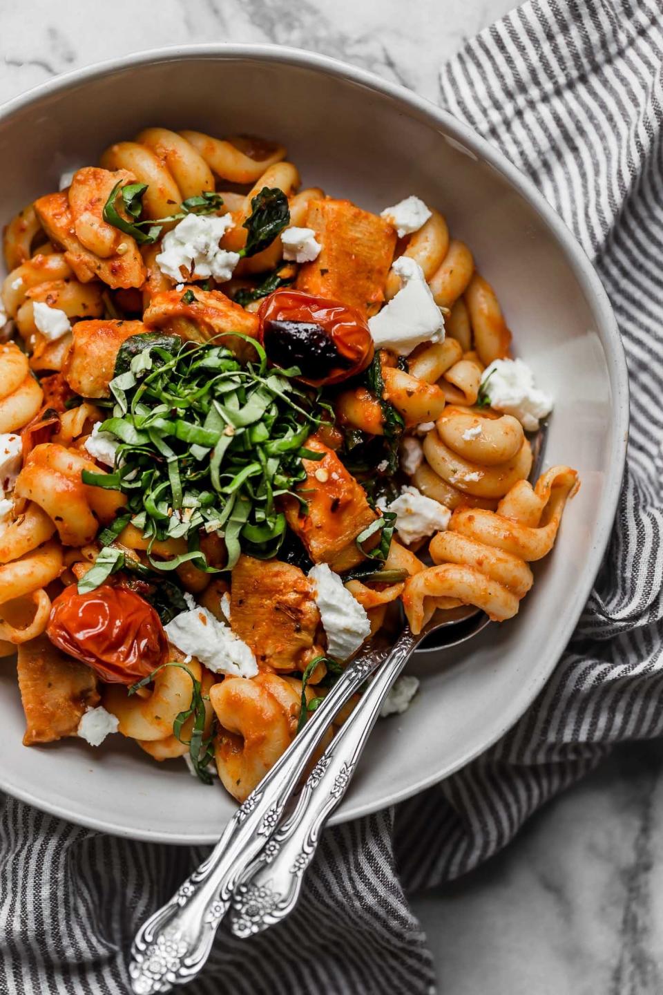 Pasta with chicken, blistered tomato, cheese, and torn basil.