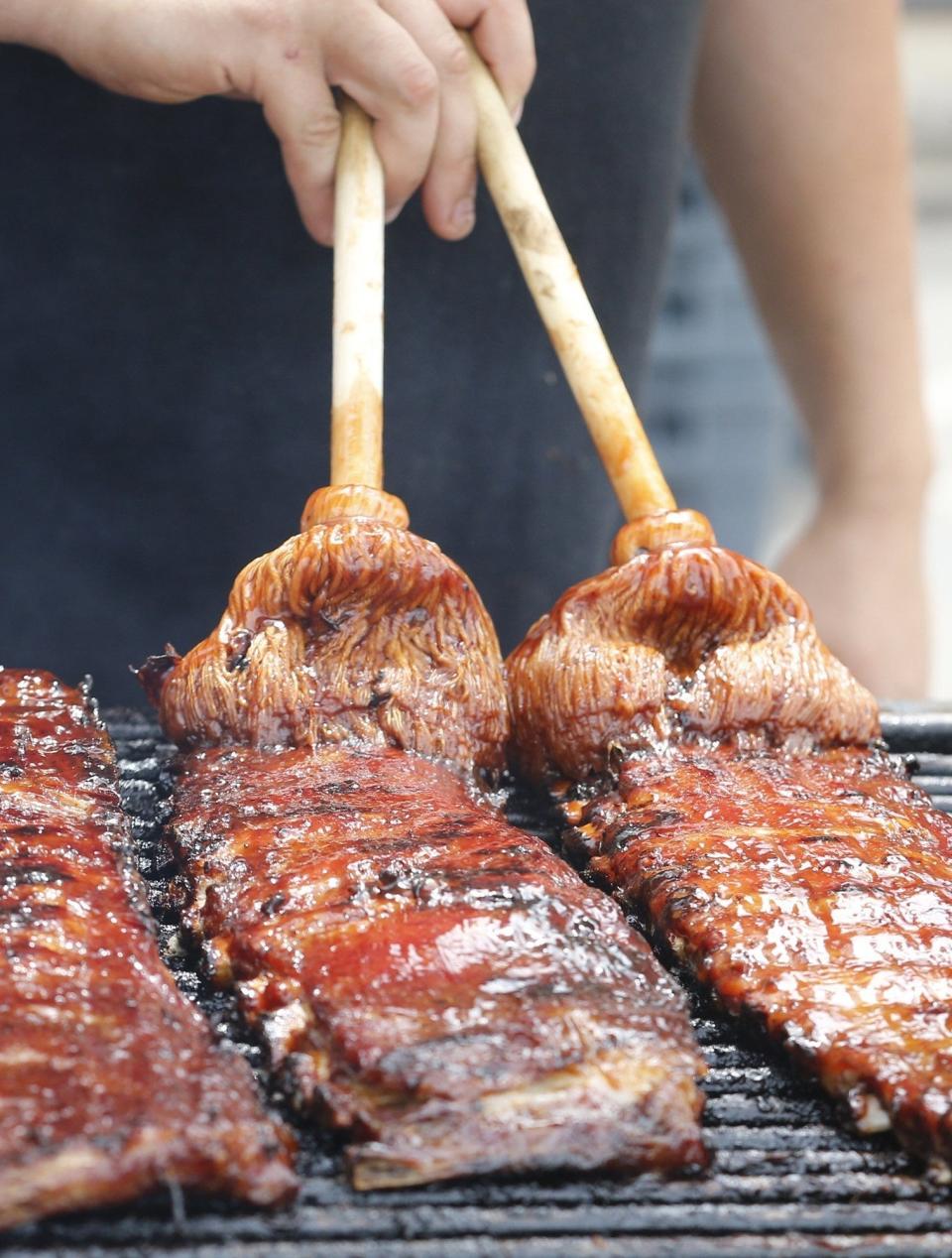 Ribs are brushed with sauce at Akron's 2019 Rib, White, and Blue Festival.