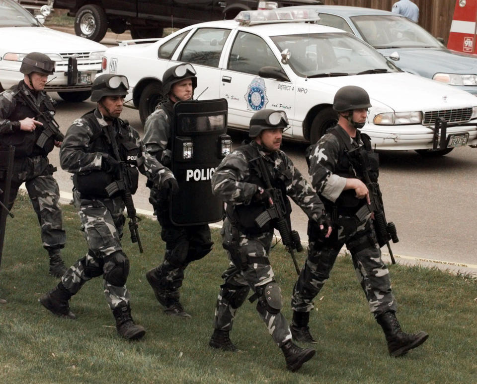 FILE - In this April 20, 1999, file photo, members of a police SWAT team march to Columbine High School in Littleton, Colo., as they prepare to do a final search of the school after two gunmen opened fire on campus. The shooting shocked the country as it played out on TV news shows from coast to coast. (AP Photo/Ed Andrieski, File)