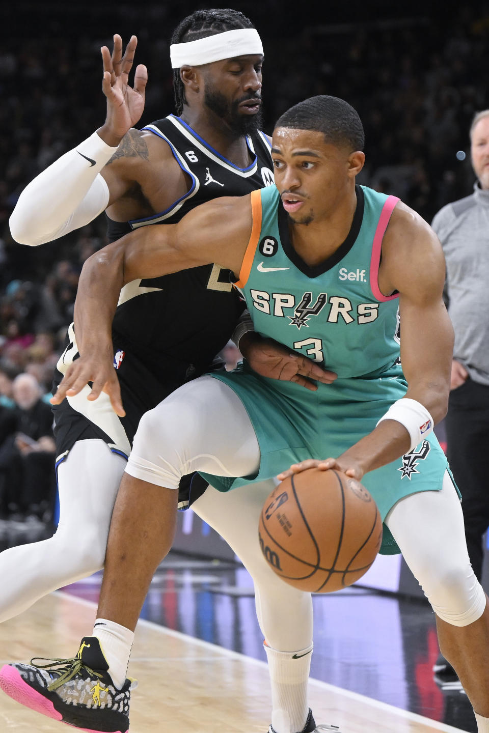 San Antonio Spurs' Keldon Johnson (3) drives against Milwaukee Bucks' Wesley Matthews during the first half of an NBA basketball game, Friday, Nov. 11, 2022, in San Antonio. (AP Photo/Darren Abate)