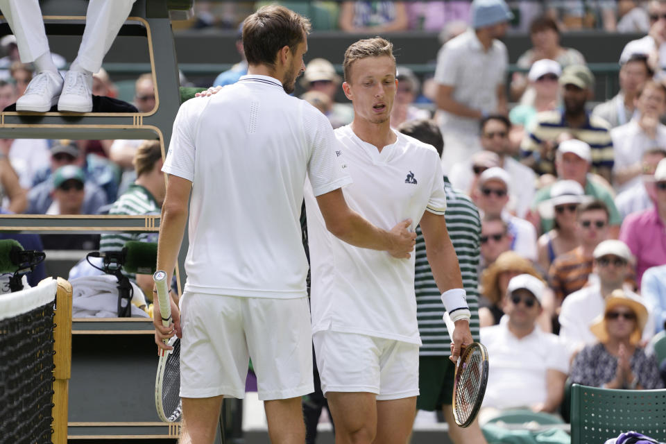 Russia's Daniil Medvedev, right, embraces Czech Republic's Jiri Lehecka after Lehecka retires from the match due to injury during their men's singles match on day eight of the Wimbledon tennis championships in London, Monday, July 10, 2023. (AP Photo/Kirsty Wigglesworth)