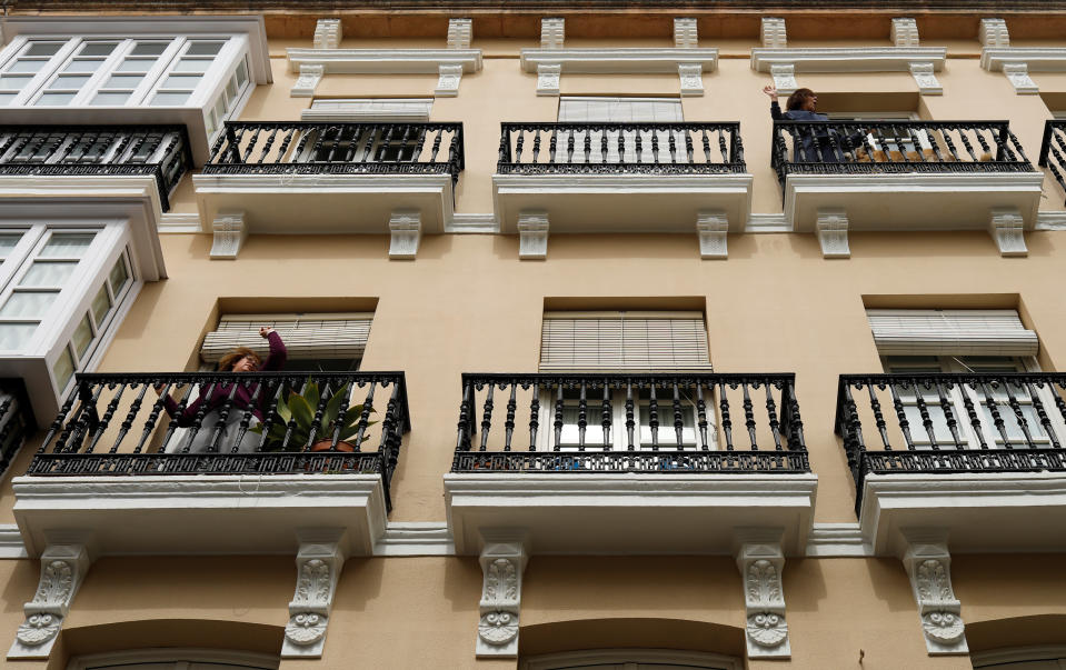 Dos mujeres hacen ejercicio mientras escuchan música en sus balcones de un edificio de viviendas de Ronda (Málaga). (Foto: Jon Nazca / Reuters).