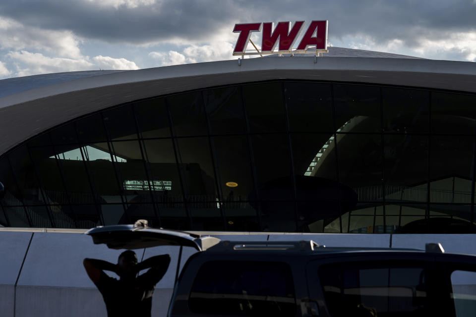 A person stands near a sign for TWA Hotel at John F. Kennedy International Airport on Tuesday, June 28, 2022, in New York. (AP Photo/Julia Nikhinson)