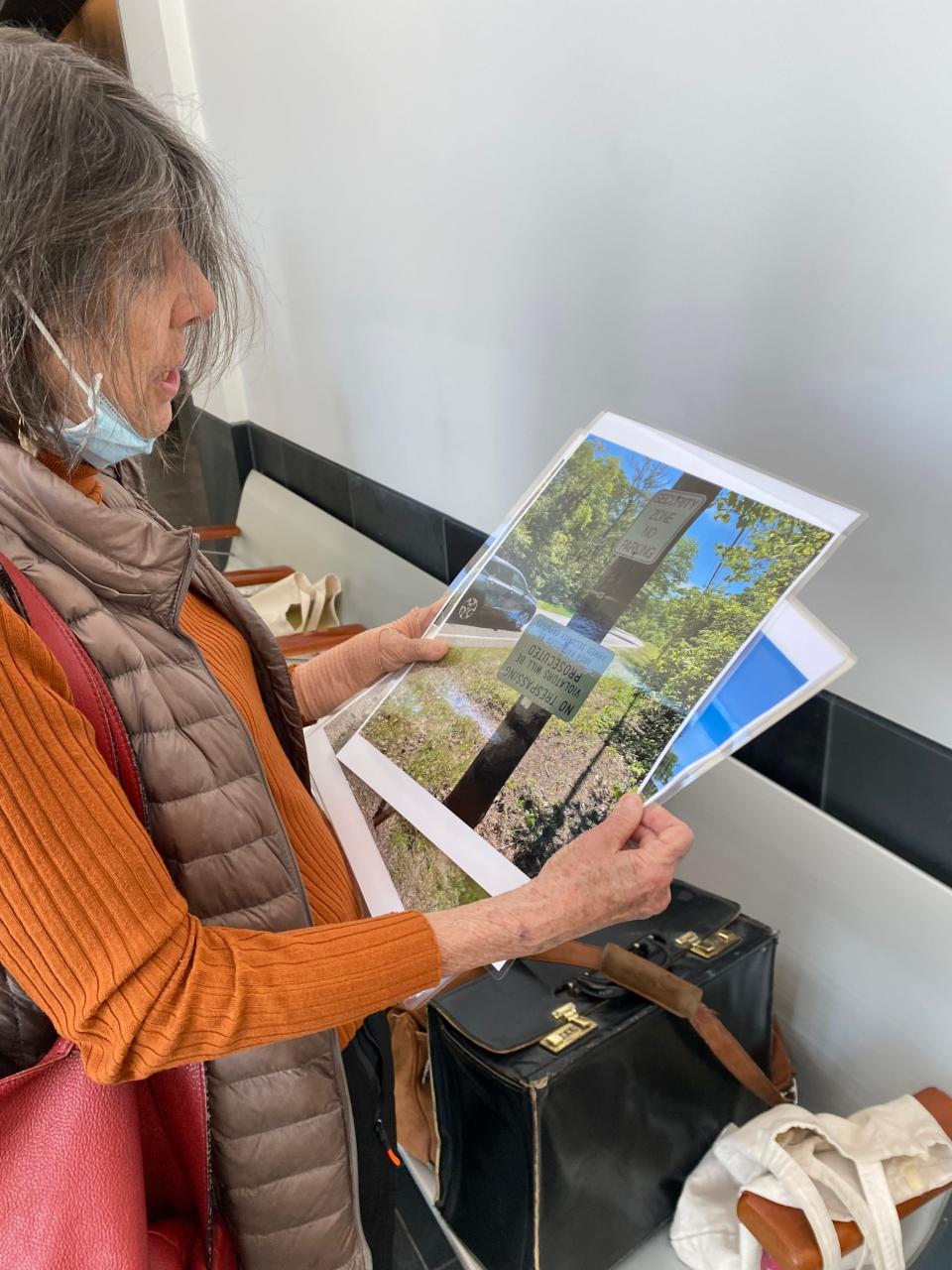 Henrietta Cosentino, Plymouth resident and supporter of Diane Turco, holds photographs she took of the plant she was planning to show to the court. Shown in the photo she is holding are two no trespassing signs. Cosentino said she executed an "unauthorized visit" onto the plant to take these photos, but wasn't stopped by security. "No trespassing, security takes notice, that's a total lie," she said.