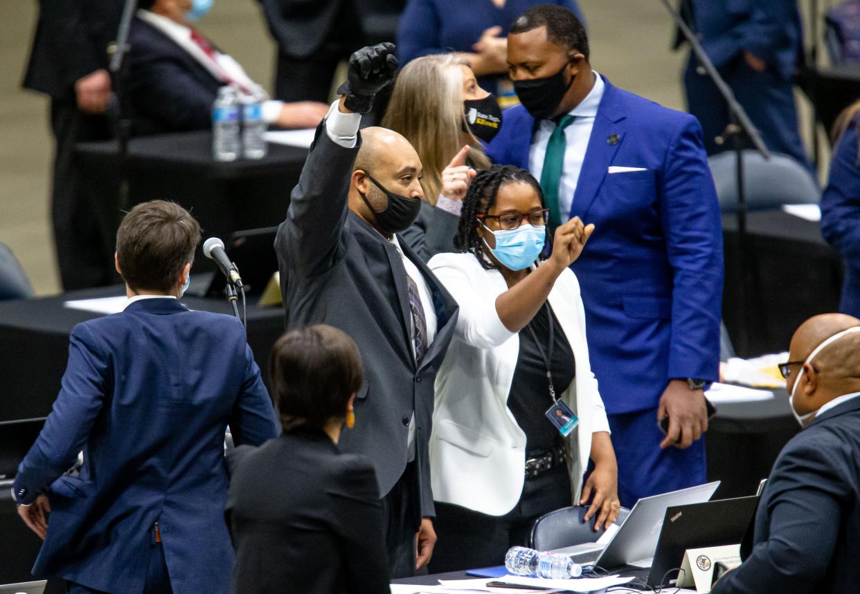 Illinois state Rep. Justin Slaughter, D-Chicago, holds up his fist while wearing a black glove after the criminal justice reform bill passes the House of Representatives during its lame-duck session at the Bank of Springfield Center on Jan. 13, 2021.