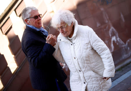 Lisel Heise (R), a 100-year-old former teacher, greets a friend as she walks through Kirchheimbolanden, Germany, April 11, 2019. REUTERS/Kai Pfaffenbach/Files