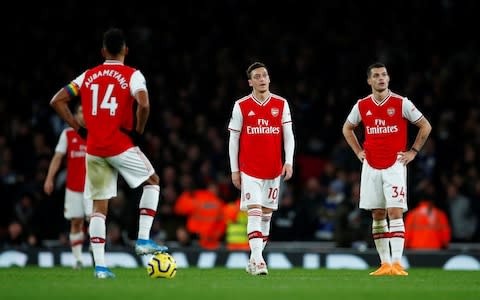 Arsenal's Mesut Ozil and Granit Xhaka look dejected after Brighton & Hove Albion's Neal Maupay scored their second goal  - Credit: REUTERS