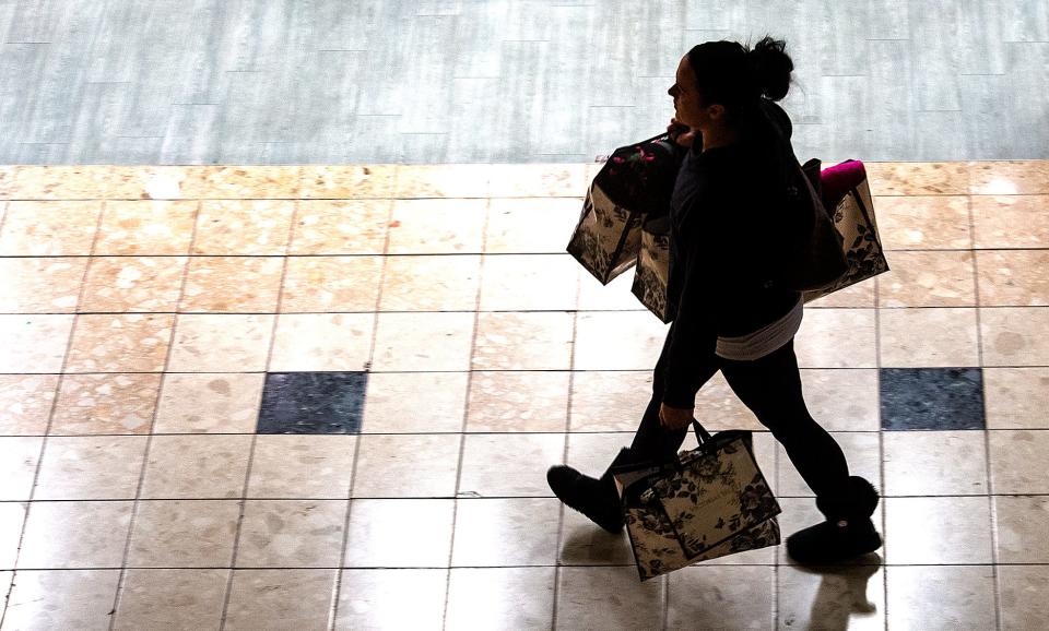 Silhouette of a shopper with her purchases on Black Friday, at the Oxford Valley Mall, in Langhorne, on Friday, Nov. 26, 2021.