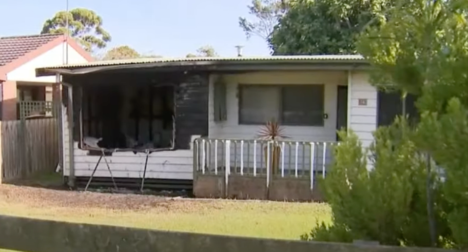 The property's front window is blackened from the fire. 