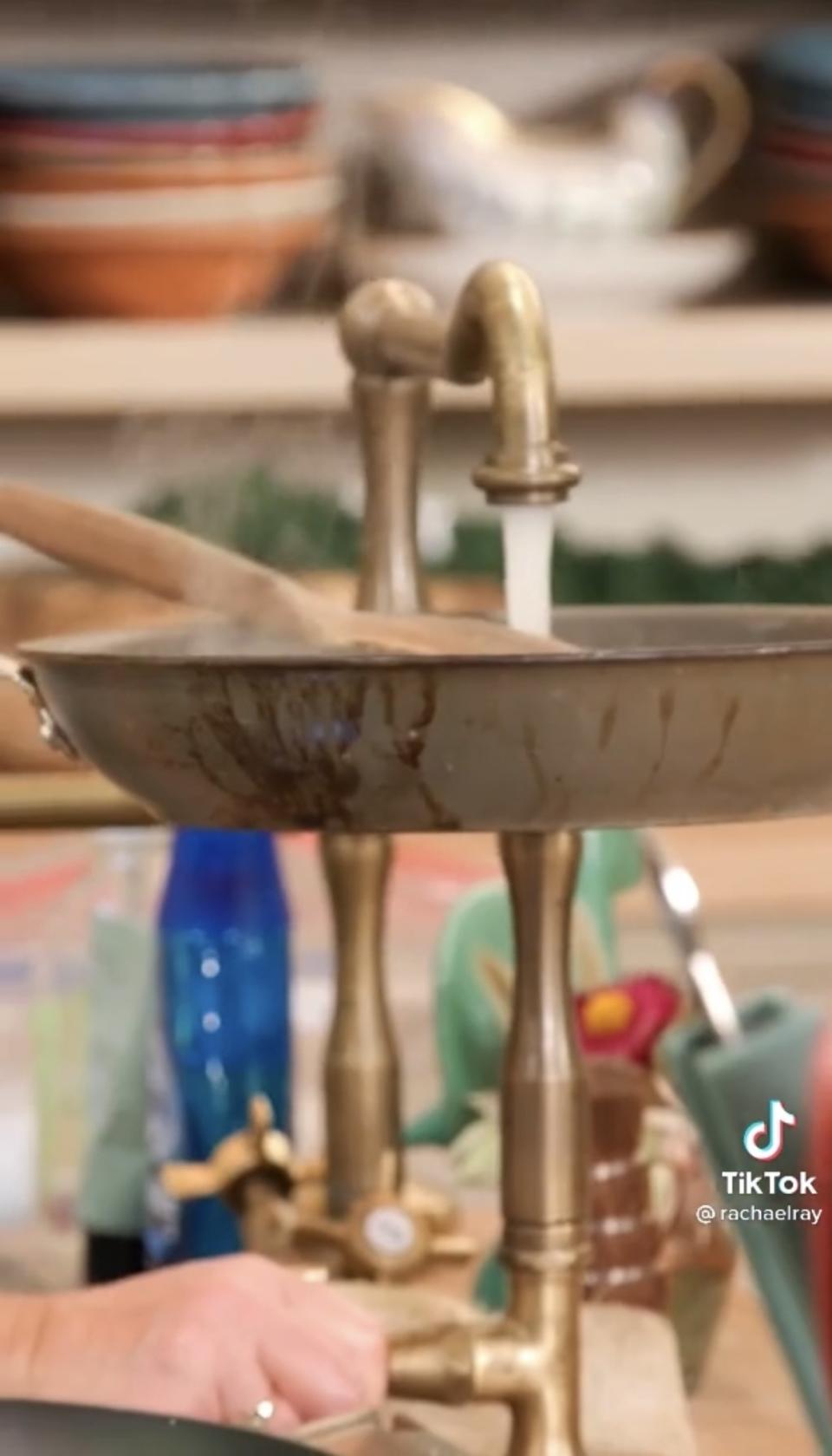 Water being poured from a sink into the skillet