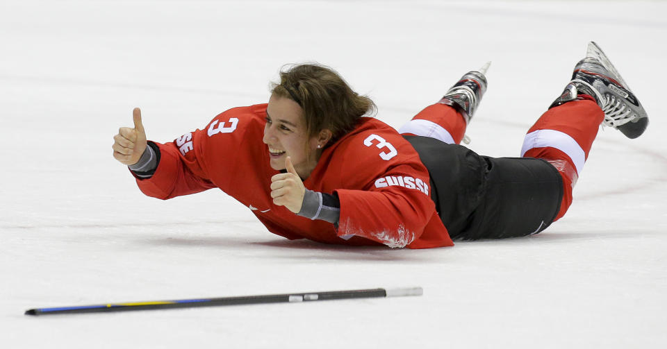 Sarah Forster of Switzerland (3) slides on the ice while celebrating Switzerland's 4-3 win over Sweden in the women's bronze medal ice hockey game at the 2014 Winter Olympics, Thursday, Feb. 20, 2014, in Sochi, Russia. (AP Photo/Matt Slocum)
