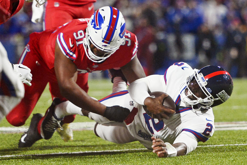 New York Giants quarterback Tyrod Taylor (2) hits the turf while being brought down by Buffalo Bills defensive tackle Ed Oliver (91) during the first half of an NFL football game in Orchard Park, N.Y., Sunday, Oct. 15, 2023. (AP Photo/Adrian Kraus)