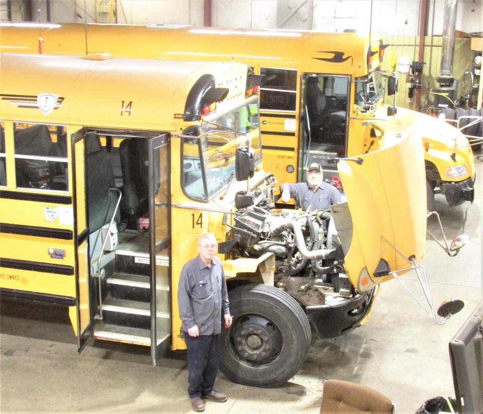 Bus mechanics Mike Phillips (front) and Brent Young serve as substitute drivers for the West Holmes Local School District.