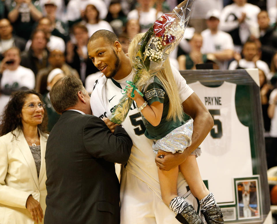 Adreian Payne, pictured here hugging coach Tom Izzo while holding Lacey Holsworth in 2014.