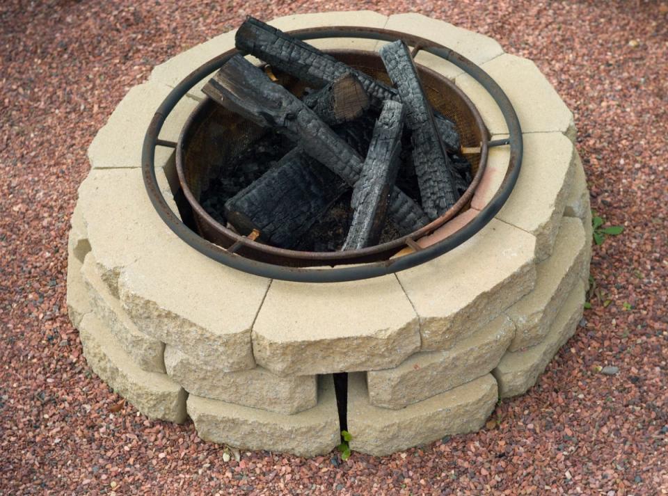 Stone fire pit with charred logs inside