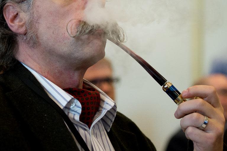 A delegate uses an e-pipe during "The E-Cigarette Summit" at the Royal Academy in central London on November 12, 2013