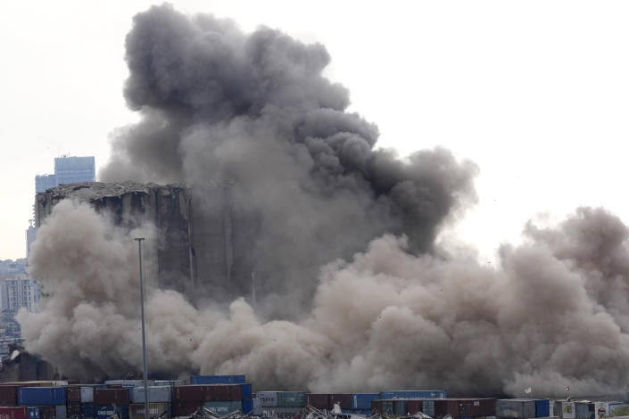 Smoke and dust cover the silos damaged during the August 2020 massive explosion in the port, in Beirut, Lebanon, Thursday, Aug. 4, 2022. A large section collapsed on Thursday as hundreds marched in Beirut to mark the second anniversary of the blast that killed scores. (AP Photo/Hussein Malla)