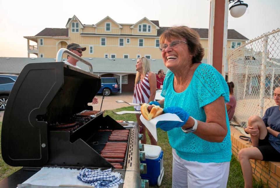 Dale Wescott, the owner of The Cavalier By The Sea motel serves hot dogs to her guests on Wednesday, July 21, 2021 in Kill Devil Hills, N.C. Built by Dale’s parents, Roy and Dot Wescott along NC 12, it opened on Memorial Day in 1950. Many generations of families return each season to enjoy the simple family friendly accommodations on the ocean.