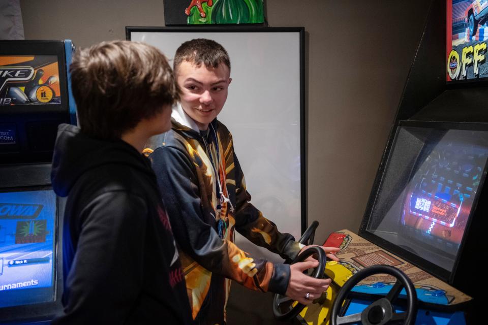 Stanton Howell, 13, left, and Tre Schapker take turns playing "Off Road" at Froggy's Restaurant in Wadesville, Ind., during Schapker's 14th birthday party Friday night, Jan. 20, 2023. 