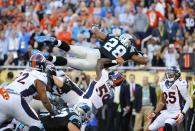 Carolina Panthers' Jonathan Stewart dives for a touchdown during the second quarter as Denver Broncos' Chris Harris Jr. (25) looks on during the NFL's Super Bowl 50 football game in Santa Clara, California February 7, 2016. REUTERS/Mike Blake (TPX IMAGES OF THE DAY)