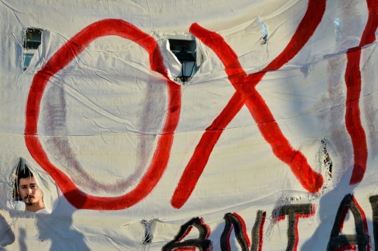 Anti-establishment protesters stand near a banner that reads, "OXI" (NO) during a demonstration against European Union's austerity in front of the Greek parliament in Athens, on July 12, 2015