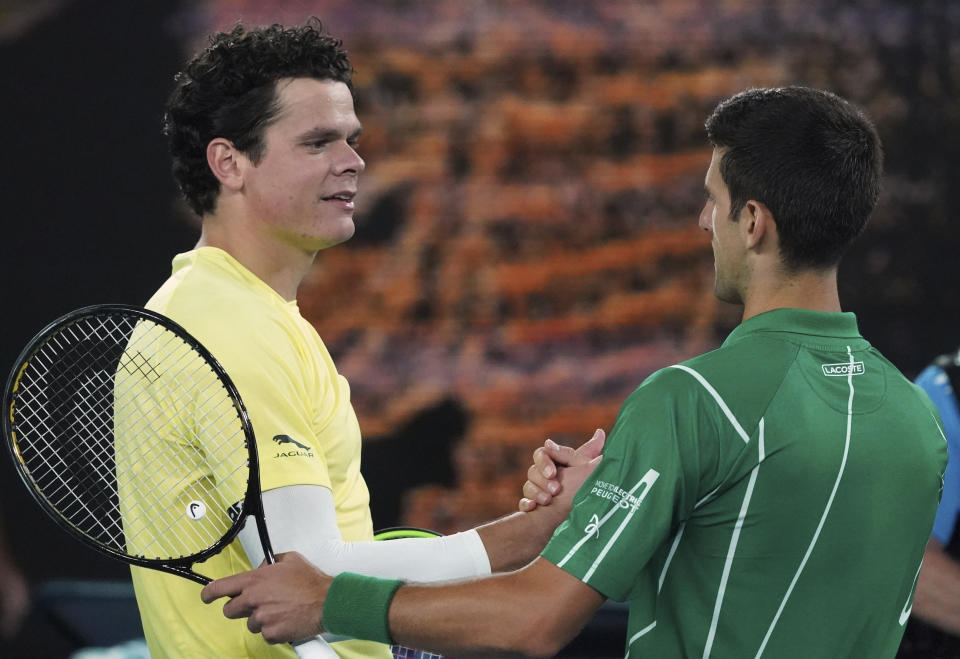 Serbia's Novak Djokovic, right, is congratulated by Canada's Milos Raonic after winning their quarterfinal match at the Australian Open tennis championship in Melbourne, Australia, Tuesday, Jan. 28, 2020. (AP Photo/Lee Jin-man)