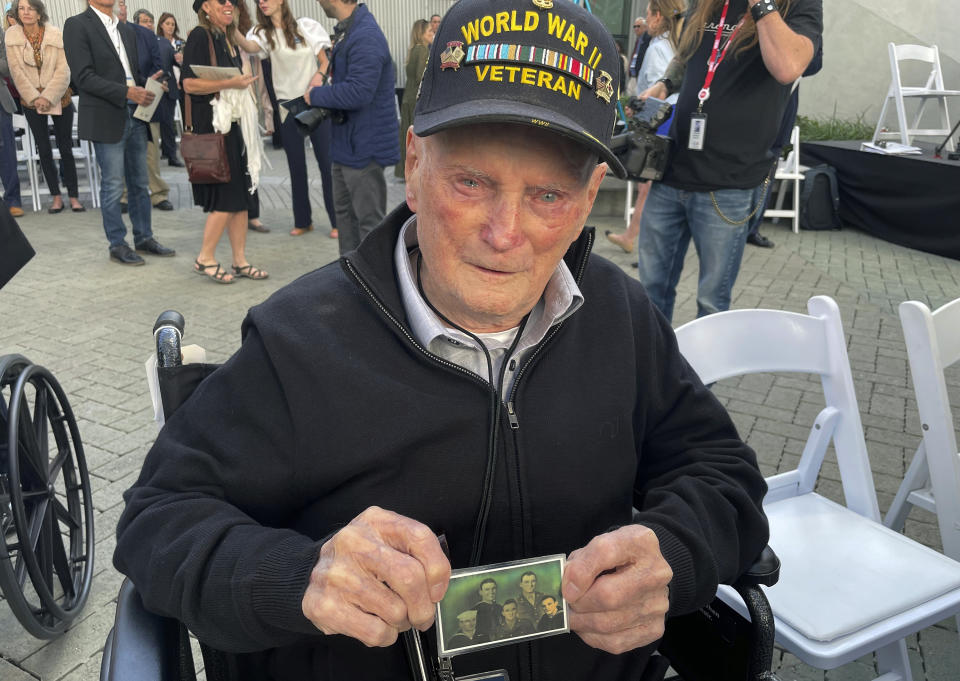 WWII veteran David McCarthy shows off a picture of himself and his Navy comrades on Friday, Nov. 3, at the National WWII Museum in New Orleans. McCarthy attended opening ceremonies for the museum's Liberation Pavilion. (AP Photo/Kevin McGill)