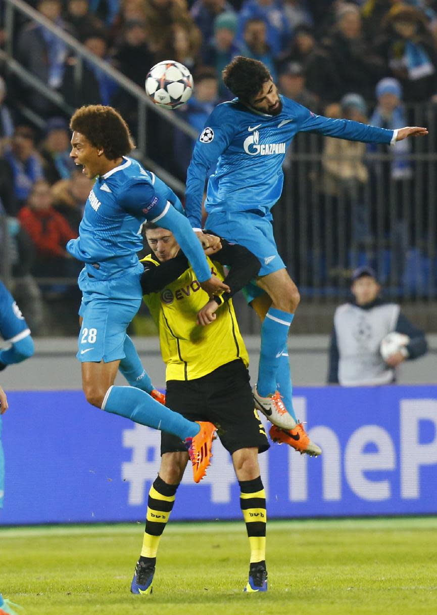 Zenit's Axel Witsel, left, and Luis Neto, right, go for a header over Borussia's Robert Lewandowski during the Champions League soccer match between Zenit St.Petersburg and Borussia Dortmund at Petrovsky stadium in St.Petersburg, Russia, on Tuesday, Feb. 25, 2014. (AP Photo/Dmitry Lovetsky)