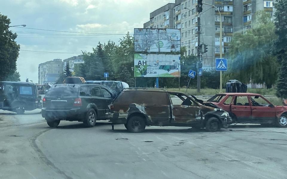 In a scene encountered by rescuers as they raced to evacuate civilians, burnt-out cars lie abandoned across a road - Andy Milburn/The Mozart Group