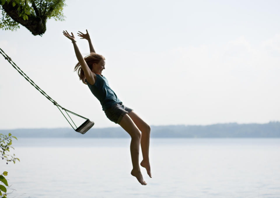 Little girl leaping from a swing.