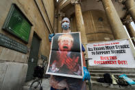 NHS staff covered in fake blood holds a poster with a depiction of Prime Minister Boris Johnson during a protest outside BBC Broadcasting Housem to demand 15% pay rise for NHS workers on 12 September, 2020 in London, England. Protesters demonstrate against not being included in the government's pay deal for 900,000 public sector workers amid the sacrifices and hardship experienced during the coronavirus pandemic. (Photo by WIktor Szymanowicz/NurPhoto via Getty Images)