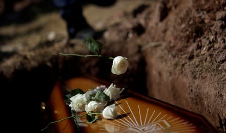 Relatives throw flowers on the coffin of DJ Joao Vitor, who was shot dead holding a drilling machine during a police operation in Santa Maria slum, in Rio de Janeiro