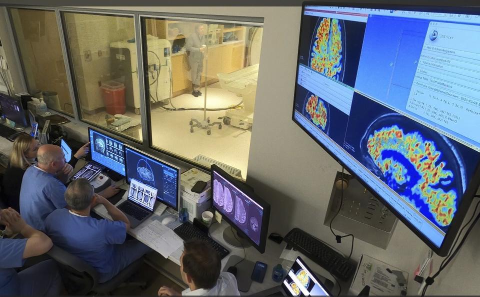 In this photo provided by the WVU Rockefeller Neuroscience Institute, the WVU RNI team in the MRI suite’s control area, plans ultrasound blood-brain barrier treatment in Morgantown, W.Va., on April 11, 2023. Scientists have found a way to help Alzheimer’s drugs seep inside the brain faster _ by temporarily breaching its protective shield. (Victor Finomore/WVU Rockefeller Neuroscience Institute via AP)