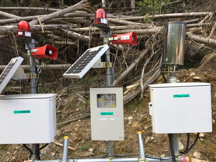 Solar powered rain gauges attached to red loudspeakers.