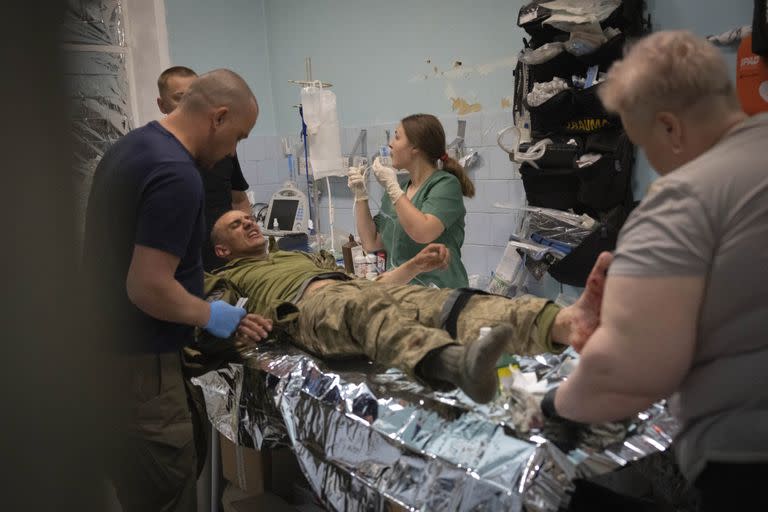 Médicos militares prestan primeros auxilios a soldados ucranianos heridos en un punto de estabilización médica cerca de Bakhmut, región de Donetsk, Ucrania, miércoles 24 de mayo de 2023.