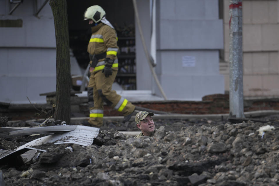 A soldier looks up as he stands in hole caused by a Russian attack in Kyiv, Ukraine, Thursday, March 21, 2024. Around 30 cruise and ballistic missiles were shot down over Kyiv on Thursday morning, said Serhii Popko, the head of Kyiv City Administration. The missiles were entering Kyiv simultaneously from various directions in a first missile attack on the capital in 44 days. (AP Photo/Vadim Ghirda)