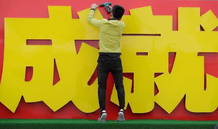 A man works outside Beijing Exhibition Centre for an exhibition displaying China's achievements for the past five years in Beijing, as the capital prepares for the 19th National Congress of the Communist Party of China, October 10, 2017. The words read, "Achievement". REUTERS/Jason Lee