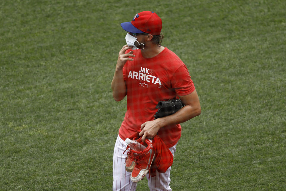 Philadelphia Phillies' Aaron Nola adjusts his mask during baseball practice at Citizens Bank Park, Monday, July 6, 2020, in Philadelphia. (AP Photo/Matt Slocum)