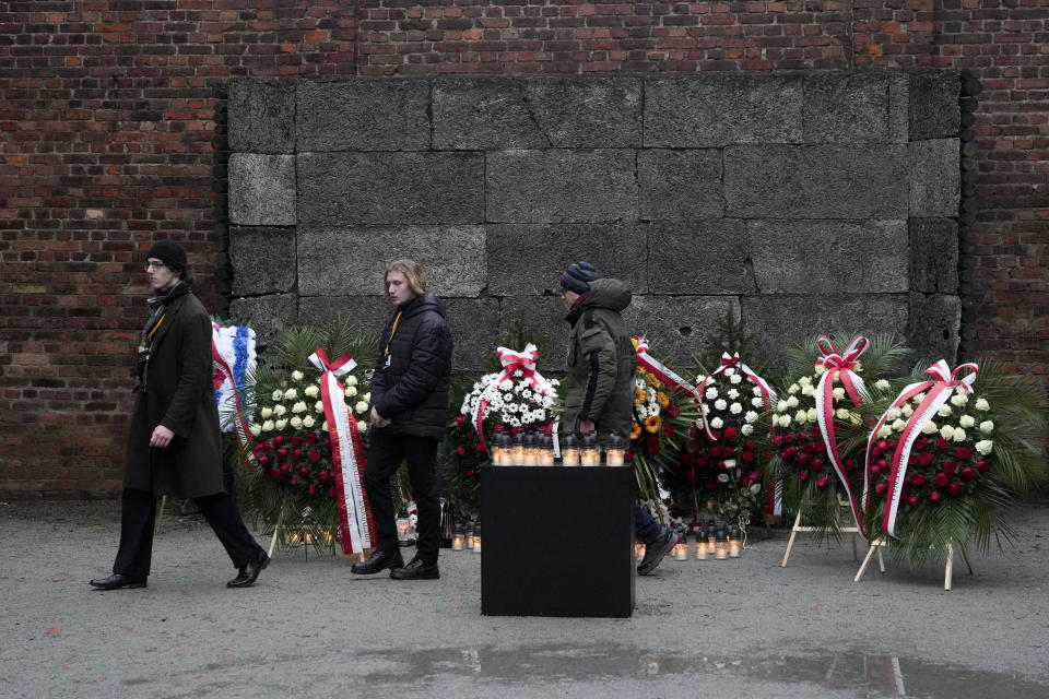 People walk by the Death Wall at the Auschwitz Nazi death camp in Oswiecim, Poland, Saturday, Jan. 27, 2024. Survivors of Nazi death camps marked the 79th anniversary of the liberation of the Auschwitz-Birkenau camp during World War II in a modest ceremony in southern Poland.(AP Photo/Czarek Sokolowski)