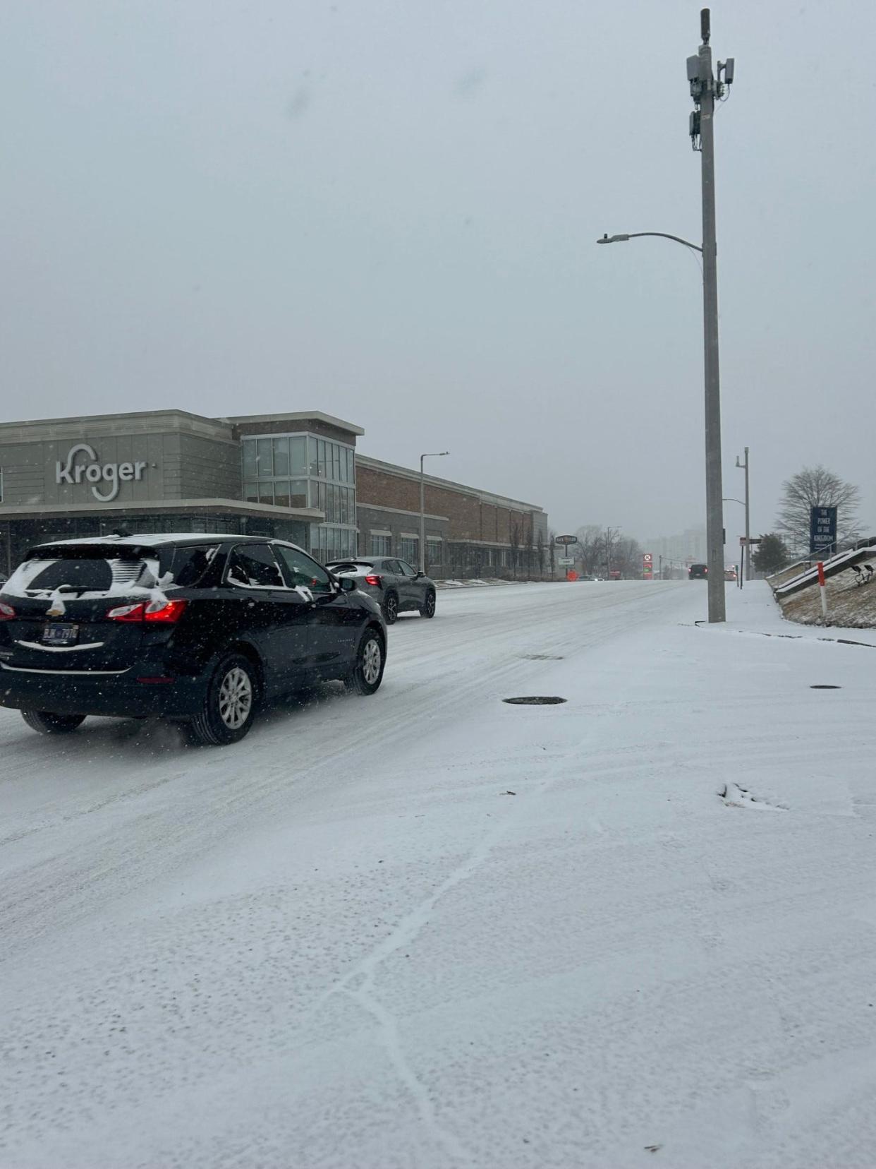 A car is seen driving down Union Avenue as snow falls in Memphis on Sunday, Jan. 14, 2024. The Memphis area is expecting 3 to 6 inches of snow and below-freezing temperatures.