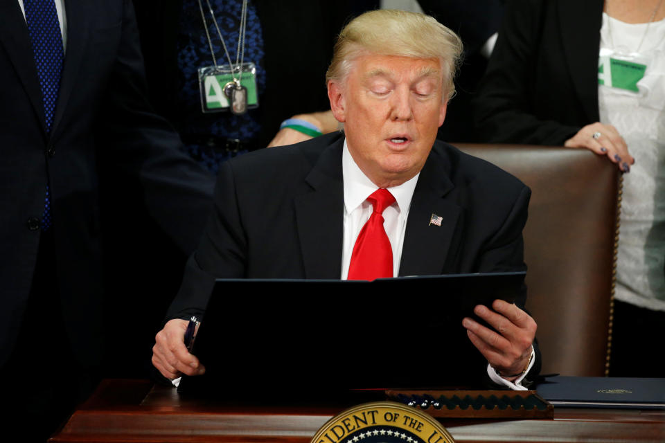 U.S. President Donald Trump reads an executive order before signing it at Homeland Security headquarters in Washington, U.S., January 25, 2017. REUTERS/Jonathan Ernst