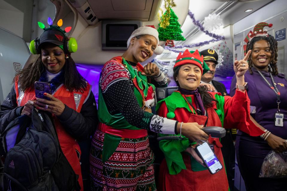 From left to right: Delta employees Terrah Lerner, Latoya Petree, Caroline Suarez, and Hope Williams sing a Christmas song to dozens of passengers during the Flight to the North Pole event at the Detroit Metropolitan Airport on Tuesday, Dec. 12, 2023.