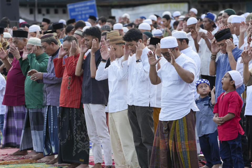 Muslims perform a morning prayer marking the Eid al-Adha holiday on a street in Jakarta, Indonesia, Thursday, June 29, 2023. Muslims around the world will celebrate Eid al-Adha, or the Feast of the Sacrifice, slaughtering sheep, goats, cows and camels to commemorate Prophet Abraham's readiness to sacrifice his son Ismail on God's command. (AP Photo/Tatan Syuflana)