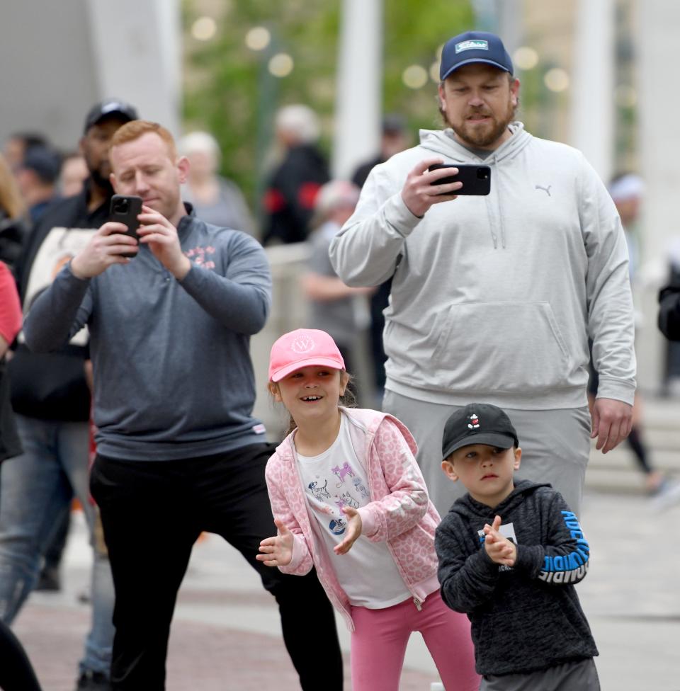 Anthony Ginella, left, of North Canton, cheers on girlfriend, Sarah Hakola, as Jordan Grubb of North Canton cheers on his wife, Bethany Grubb, with his kids Mara, 7, and Judah Grubb, 5, in downtown Canton for the Sunday events of the 10th Canton Hall of Fame Marathon race weekend.