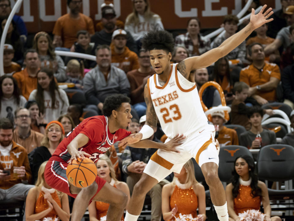 Texas forward Dillon Mitchell, right, defends the drive by Louisiana-Lafayette guard Kentrell Garnett, left, during the first half of an NCAA college basketball game, Wednesday, Dec. 21, 2022, in Austin, Texas. (AP Photo/Michael Thomas)